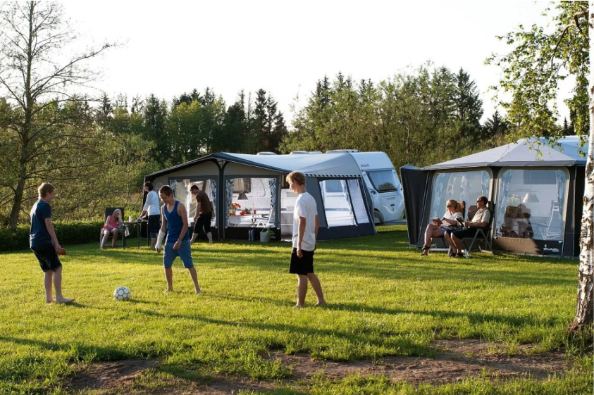 Des enfants jouent au football sur la pelouse du camping