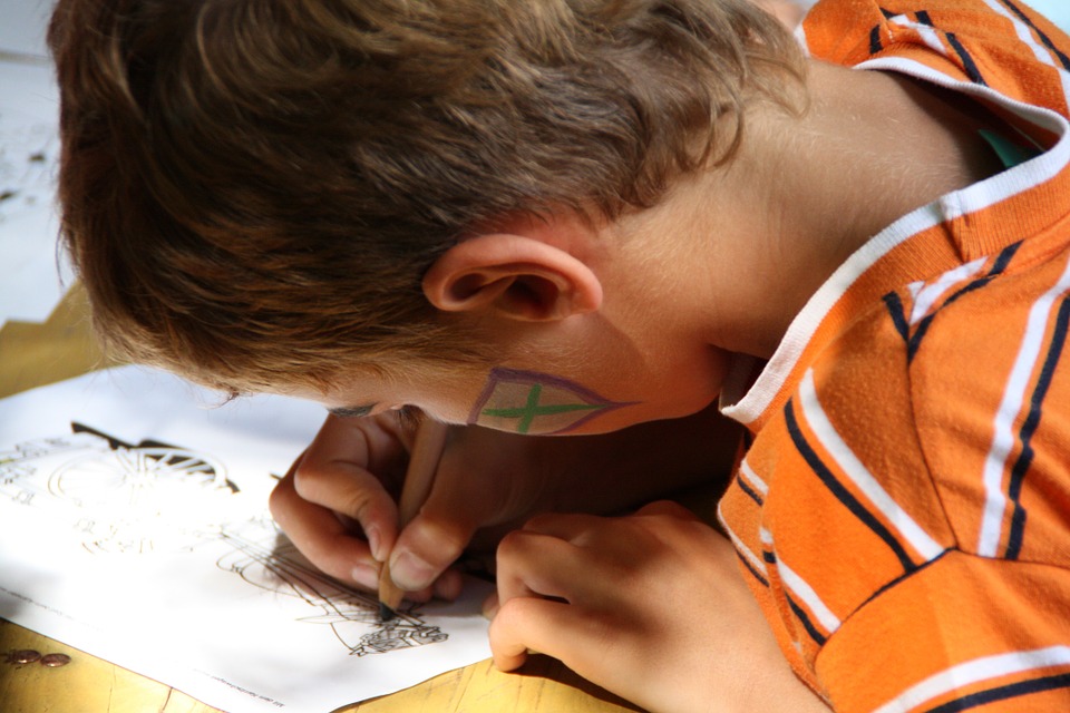 Un enfant dessine dans un livre de coloriage